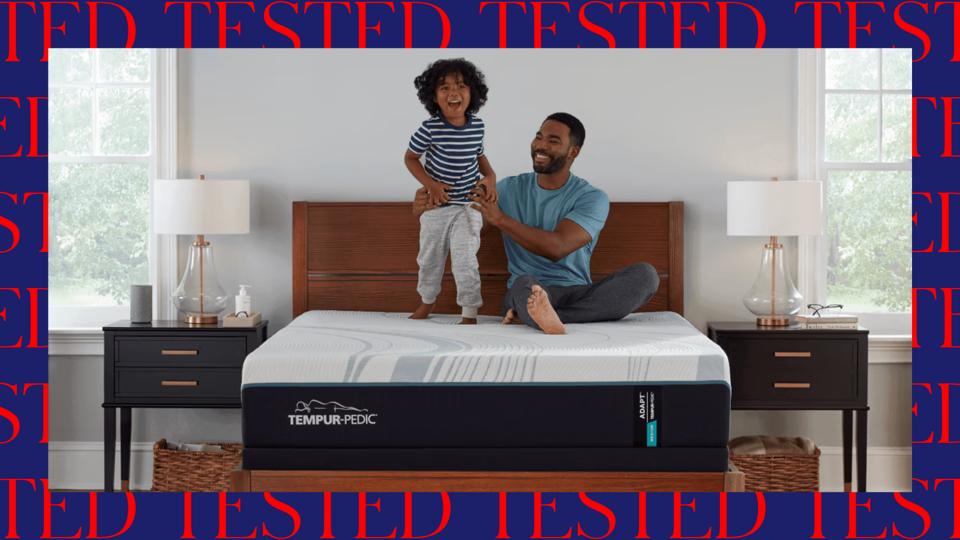 A man sitting on a Tempur-Pedic Mattress with his child.