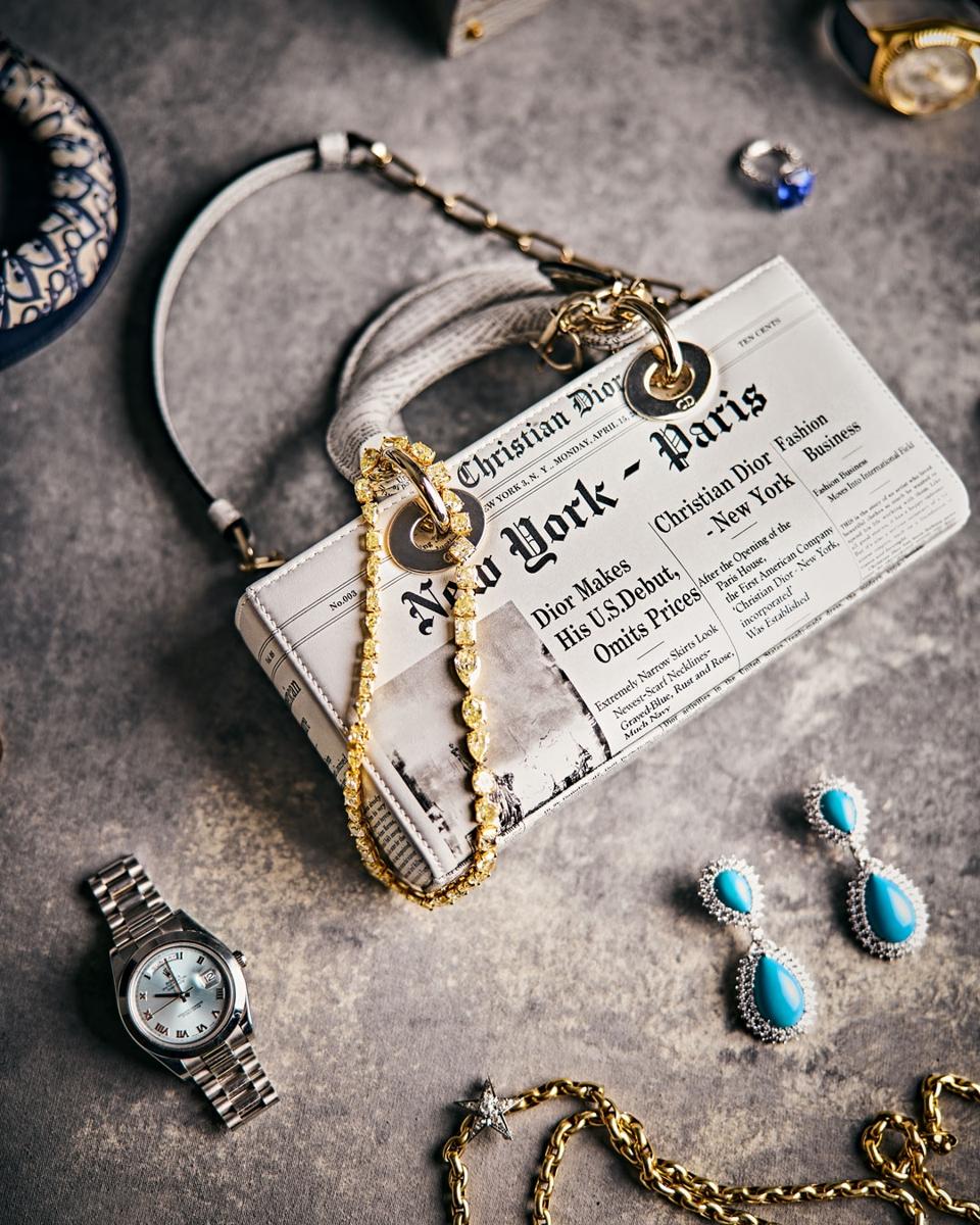 Photograph of a Chanel bag and several pieces of fine jewelry.