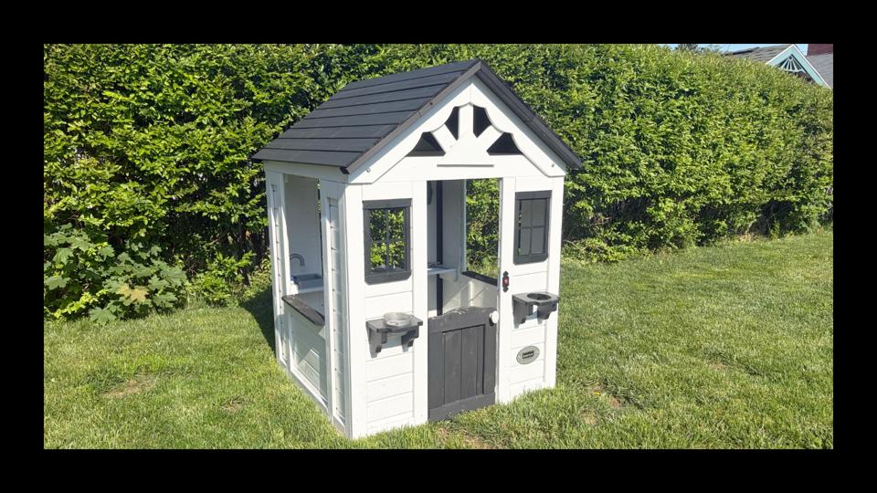 White and black backyard discovery playhouse outside