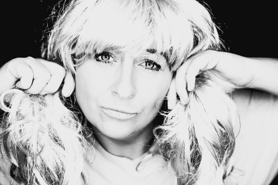 Close-Up Portrait Of Woman Wearing Wig Against Black Background