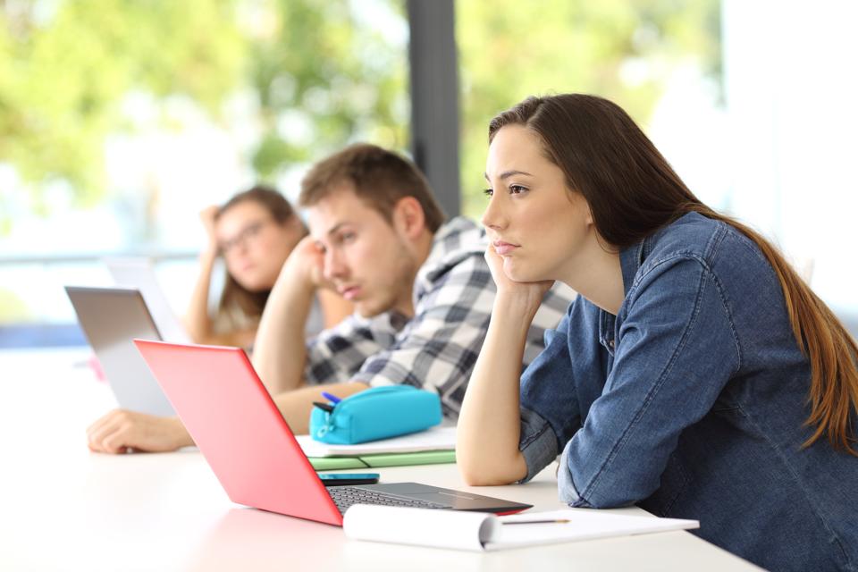 Bored students listening lesson in a classroom