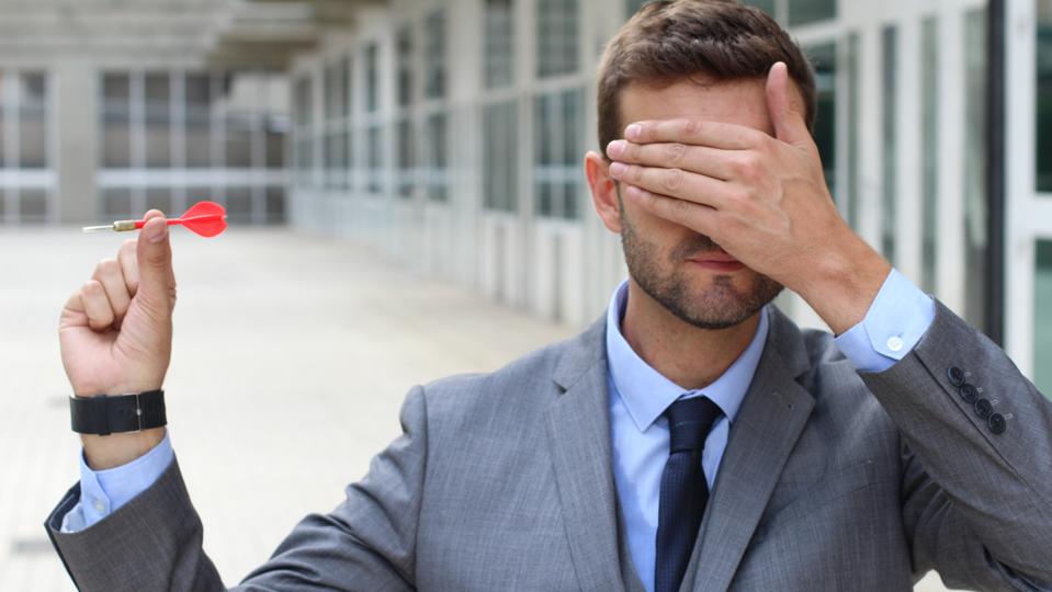 Blind businessman holding a dart