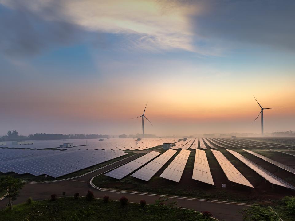 Solar power plants and wind turbines at sunrise.
