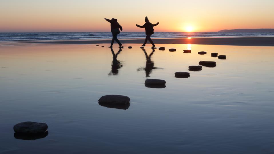 Stepping stones over water, two people