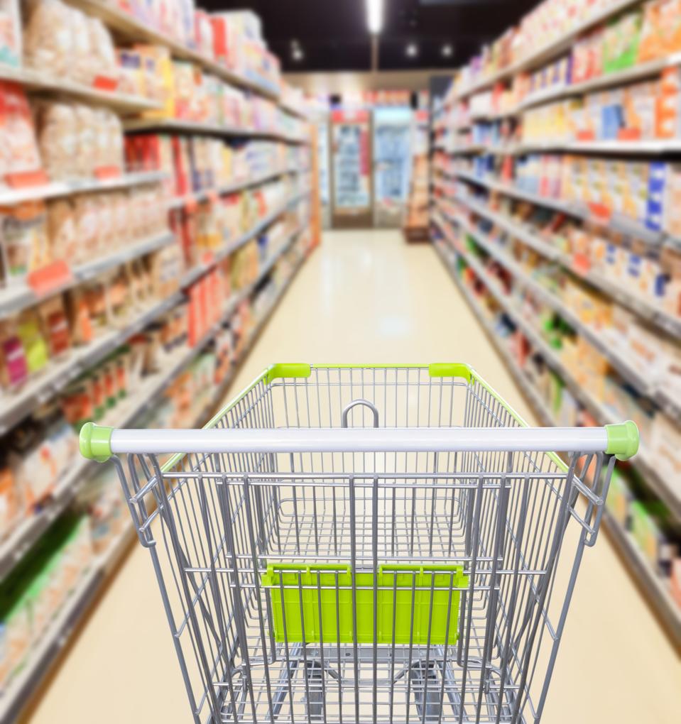 Supermarket aisle with empty shopping cart business concept