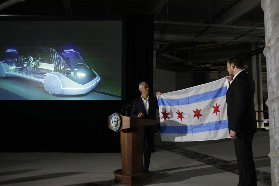 Chicago Mayor Rahm Emanuel presents a Chicago flag to Elon Musk during a news conference at Block 37 on June 14, 2018 in Chicago. Musk said he could create a 16-passenger vehicle to operate on a high-speed rail system that could get travelers to and