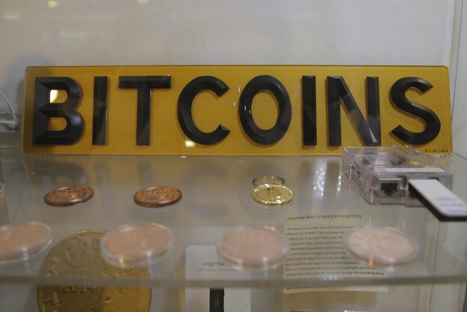   Coins and sign are displayed in Hong Kong on December 8, 2017. 